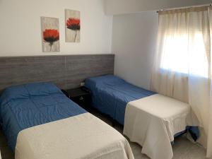 a room with two beds and a window with at Supercéntrico la Docta in Cordoba