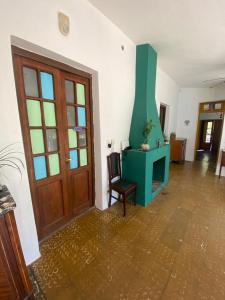 a living room with a green fireplace and a chair at Hospedaje centro erks in Capilla del Monte