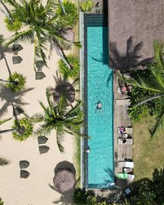 an overhead view of a swimming pool with palm trees at ANGKLA Beach Club & Boutique Resort in El Nido