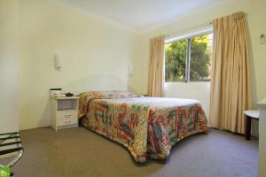 um quarto com uma cama e uma janela em Bel Mondo Apartments em Wollongong