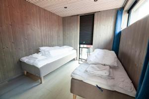 ヘニングスヴァールにあるBryggeleilighet i Henningsværのウッドパネルの壁の客室で、ベッド2台が備わります。