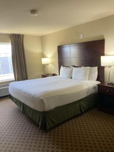 a hotel room with a large bed and a window at Cobblestone Hotel & Suites - Broken Bow in Broken Bow