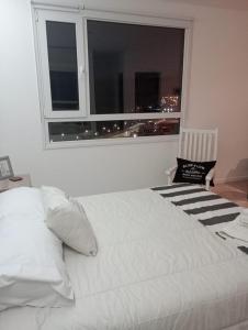 a white bed in a room with a window at Paisaje 1 in Comodoro Rivadavia