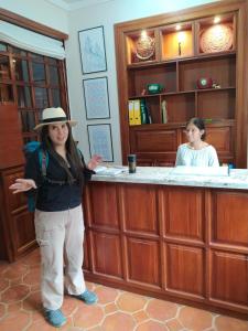 uma mulher de chapéu em frente a um bar em Hotel Posada de María em Cuenca