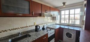 a kitchen with a stove and a washing machine at Atractivo in Rosario