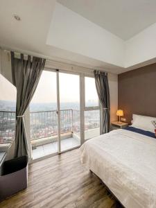 a bedroom with a large bed and large windows at Contemporary Comfort Sleek Studio Casa De Parco in Samporo
