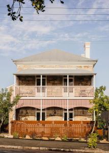 una casa con una recinzione di legno di fronte ad essa di Miss Midgley's - Refectory a Brisbane