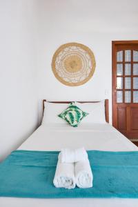 ein Schlafzimmer mit einem Bett mit Handtüchern darauf in der Unterkunft Casa Luz do Sol Próximo do Centro in Paraty