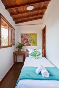 um quarto com uma cama e um tecto em madeira em Casa Luz do Sol Próximo do Centro em Paraty
