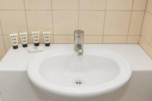 a white bathroom sink with a faucet at Northcote Charm Spacious and Quiet Suburban Stay in Melbourne