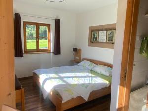 a bedroom with a bed and a window at Hansenbauernhof in Ruhpolding