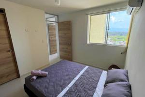 ein Schlafzimmer mit einem Bett und einem großen Fenster in der Unterkunft AG APTO con Aire Acondicionado in Neiva