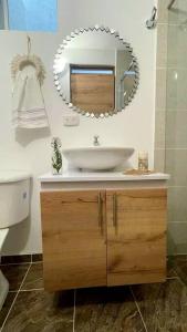 baño con lavabo y espejo en la pared en AG APTO con Aire Acondicionado, en Neiva