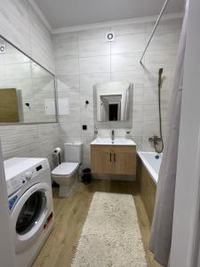 a bathroom with a washer and a washing machine in it at Grand Champion Astana in Taldykolʼ