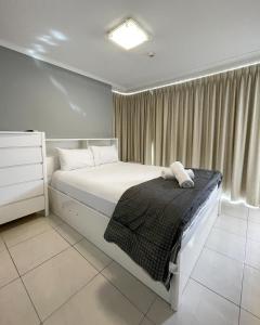a bedroom with a white bed and a window at Baronnet Apartments in Gold Coast