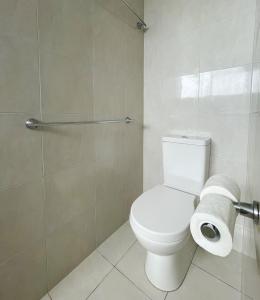 Baronnet Apartments في غولد كوست: حمام مع مرحاض ولفافتين من ورق التواليت