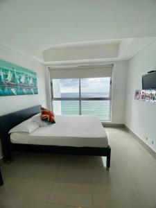 a bedroom with a large bed with a large window at Apartamentos Cartagena Oceano - Eliptic in Cartagena de Indias