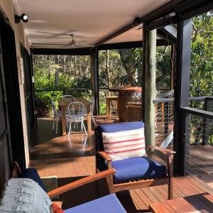 un porche cubierto con sofá y silla en Hillside Retreat Guest House, en Bli Bli