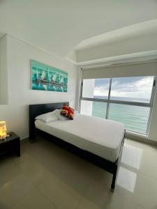a bedroom with a large bed and a large window at Apartamentos Cartagena Oceano - Eliptic in Cartagena de Indias