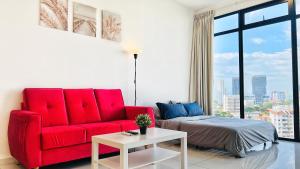 a living room with a red couch and a bed at Beacon Executive Suite #InfinityPool #Penang #GeorgeTown in George Town