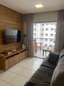 een woonkamer met een bank en een flatscreen-tv bij Luxuoso Apto no setor Bueno in Goiânia