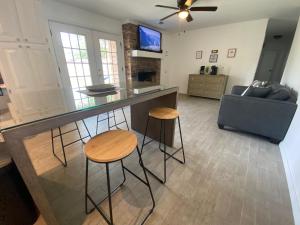 a kitchen and living room with a bar and stools at Spacious Ranch Home Near Airport in Pensacola