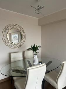 comedor con mesa de cristal y espejo en Aparment Deluxe San Isidro, en Lima