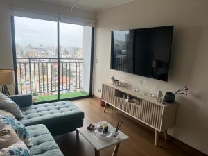 a living room with a couch and a flat screen tv at Aparment Deluxe San Isidro in Lima