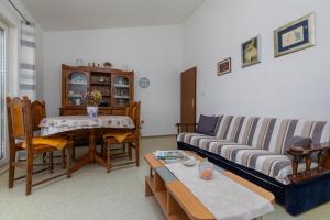 ein Wohnzimmer mit einem Sofa und einem Tisch in der Unterkunft Apartments with a parking space Dugi Rat, Omis - 11483 in Dugi Rat