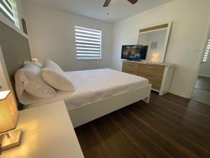 a bedroom with a bed and a dresser with a television at Spacious Ranch Home Near Airport in Pensacola
