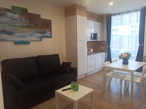 uma sala de estar com um sofá e uma mesa em Apartamentos Silgar Plaza em Sanxenxo