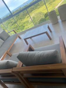 - un salon avec des canapés et une grande fenêtre dans l'établissement Panama's Paradise Playa Blanca Ocean & Pool View, à Río Hato