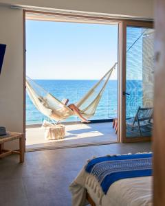 a bedroom with a hammock and a view of the ocean at Hotel Basalto in Punta Mita