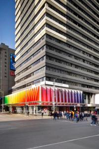 a large building with a rainbow facade in a city at Urban Apartments Melbourne on Elizabeth in Melbourne