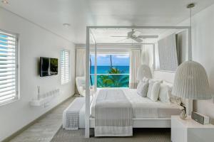 a white bedroom with a view of the ocean at FOOTPRINTS by DC in Saint James