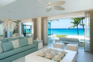 a living room with a couch and a table and the ocean at FOOTPRINTS by DC in Saint James