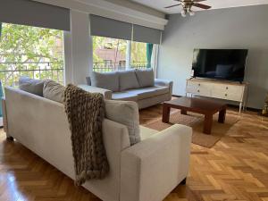uma sala de estar com um sofá e uma televisão em Exclusivo piso Mendoza centro em Mendoza