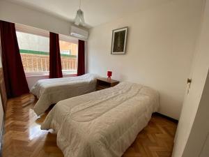 Duas camas num quarto com uma janela em Exclusivo piso Mendoza centro em Mendoza