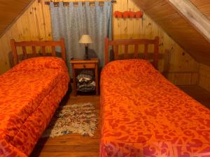 two beds sitting next to each other in a room at Cabañas La Soñada del Río in Victoria