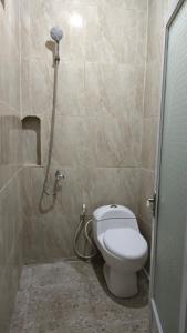 La salle de bains est pourvue d'une douche et de toilettes. dans l'établissement Hotel Artha, à Tjakranegara