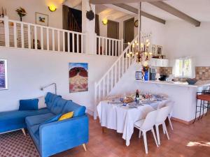 a dining room with a table and a blue couch at Charming Villa in Villes-sur-Auzon with Swimming Pool in Villes-sur-Auzon