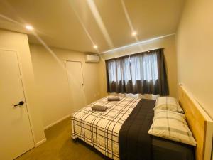 a bedroom with a bed and a window at Holiday / Short term Rent in Auckland