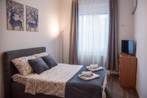 Dormitorio pequeño con cama y TV en Balkan dream **** en Belgrado
