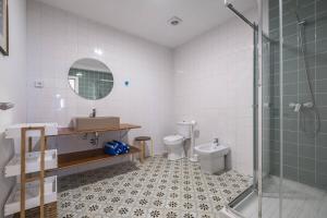 a bathroom with a toilet and a sink and a shower at Sea House in São Vicente