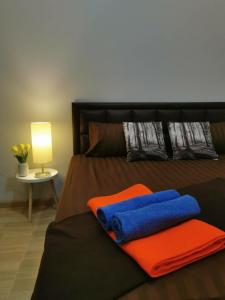 a bed with orange and blue pillows and a lamp at DPool Villa in Sattahip