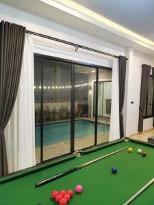 a pool table in front of a swimming pool at DPool Villa in Sattahip
