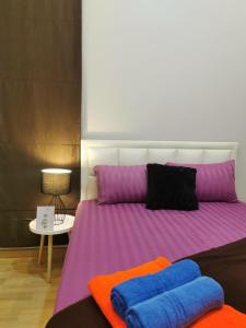 a bedroom with a bed with purple and purple sheets at DPool Villa in Sattahip