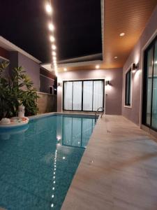 a swimming pool in a building with a tv above it at DPool Villa in Sattahip