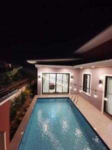 a swimming pool in a house at night at DPool Villa in Sattahip