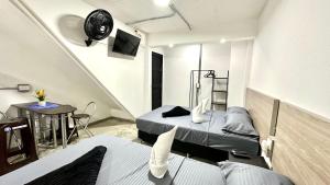 a small room with two beds and a table at SINU LOFT in Medellín